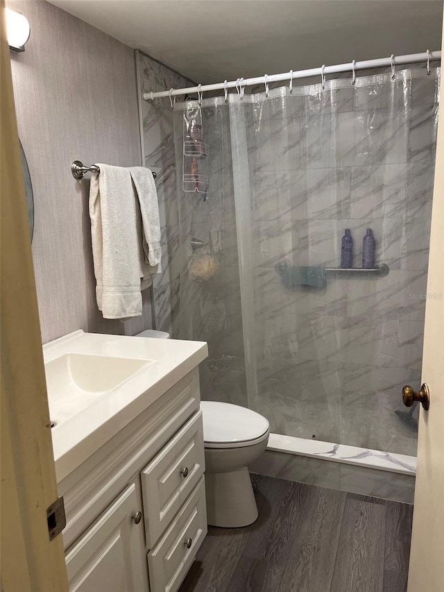 bathroom featuring a shower with shower curtain, vanity, toilet, and hardwood / wood-style floors