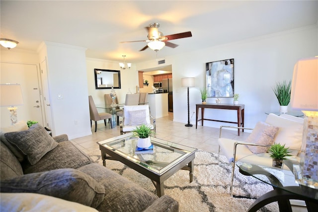 tiled living room with ceiling fan with notable chandelier and ornamental molding