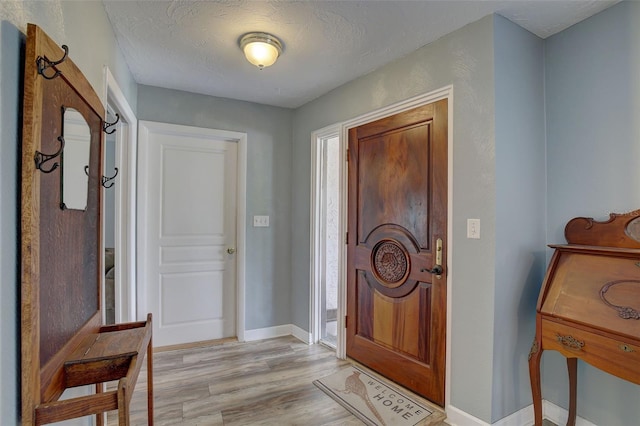 entrance foyer featuring a textured ceiling and light wood-type flooring