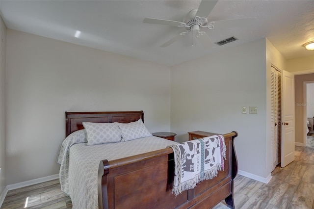 bedroom with ceiling fan, a closet, and light hardwood / wood-style flooring