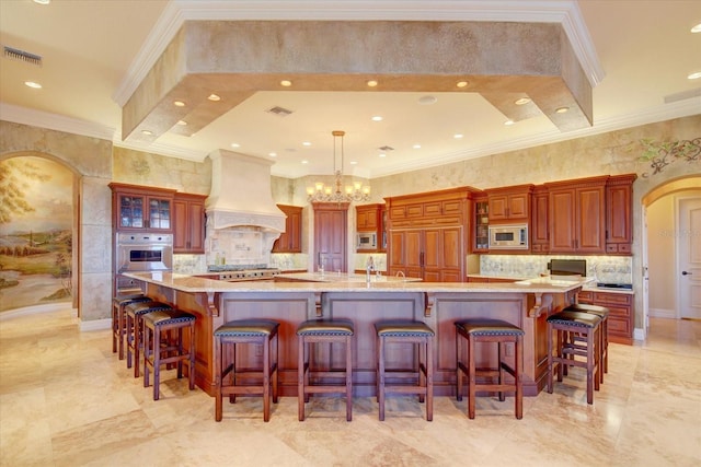 kitchen featuring appliances with stainless steel finishes, a spacious island, a kitchen breakfast bar, and custom range hood