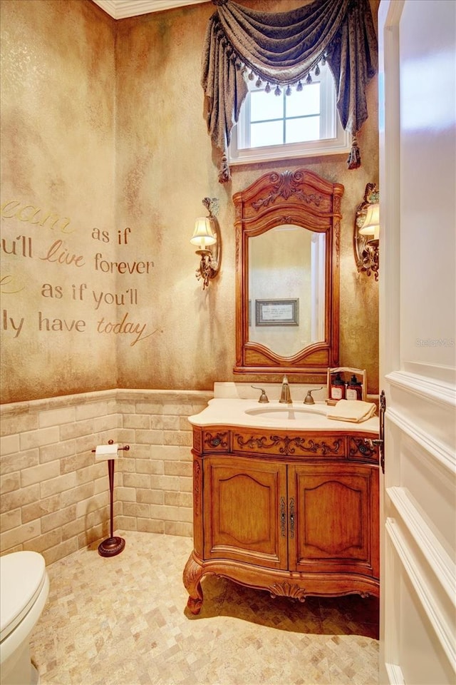 bathroom with vanity, tile patterned flooring, toilet, and tile walls