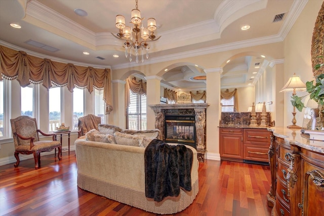 living room with crown molding, hardwood / wood-style floors, and a tray ceiling