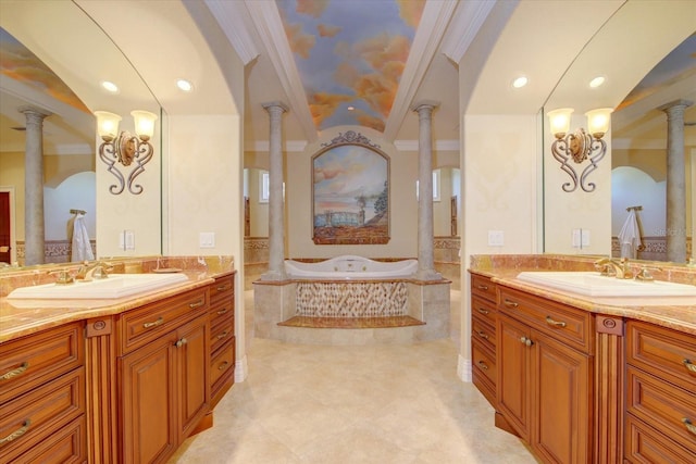 bathroom with tiled tub, dual bowl vanity, ornate columns, and tile patterned floors