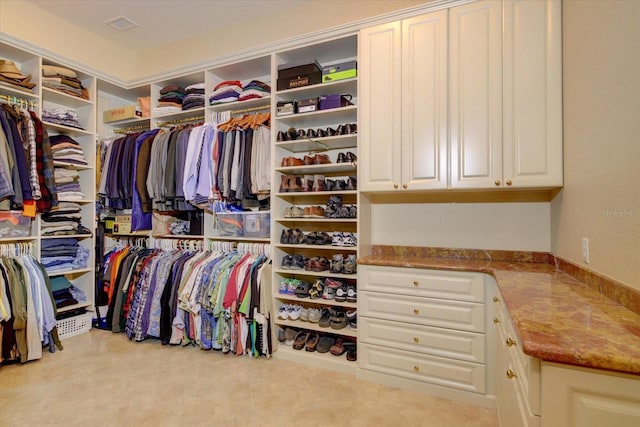 spacious closet featuring light colored carpet