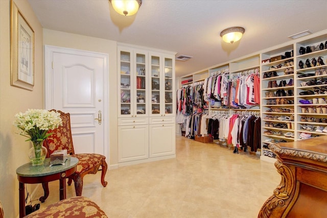 walk in closet with light tile patterned floors