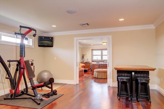 exercise room featuring ornamental molding and dark hardwood / wood-style floors