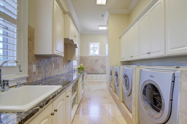 laundry room featuring light tile patterned flooring, crown molding, washing machine and dryer, cabinets, and sink