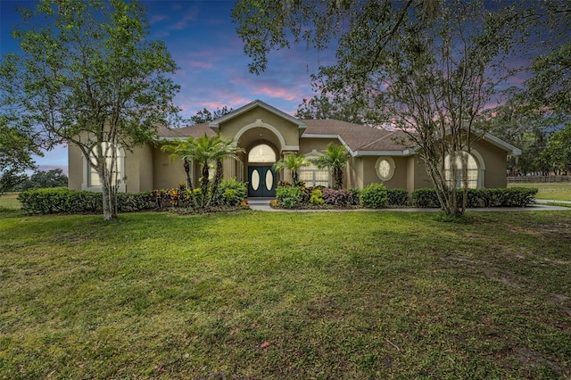 view of front facade with a front lawn and stucco siding