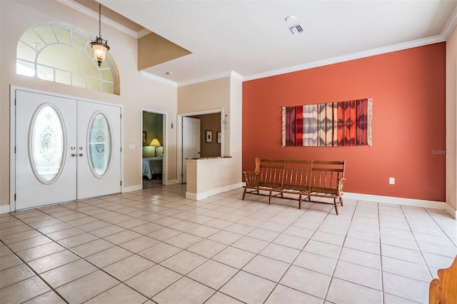 foyer with french doors, light tile patterned floors, visible vents, ornamental molding, and baseboards