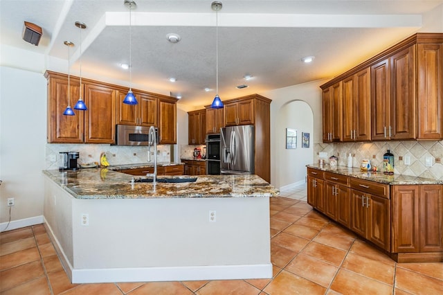 kitchen with stone countertops, arched walkways, appliances with stainless steel finishes, a peninsula, and light tile patterned flooring