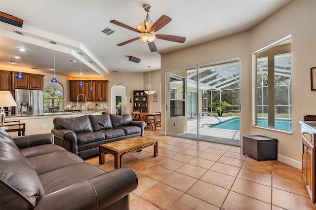 living room featuring a wealth of natural light, visible vents, baseboards, and light tile patterned floors