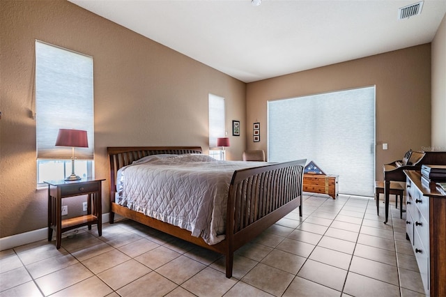 bedroom featuring light tile patterned floors, visible vents, and baseboards