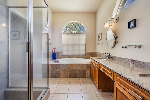 bathroom with double vanity, a stall shower, a sink, tile patterned flooring, and a bath