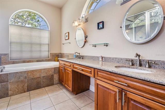 bathroom with a bath, double vanity, a sink, and tile patterned floors