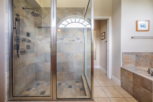bathroom with tile patterned flooring, a bath, and a shower stall
