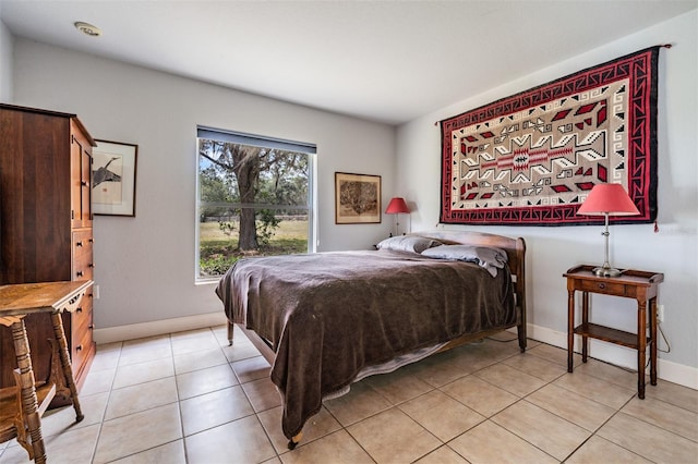 bedroom with light tile patterned flooring and baseboards