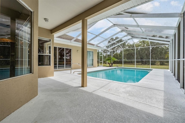 outdoor pool featuring glass enclosure and a patio area