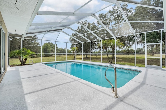 outdoor pool featuring a yard, a patio area, and glass enclosure
