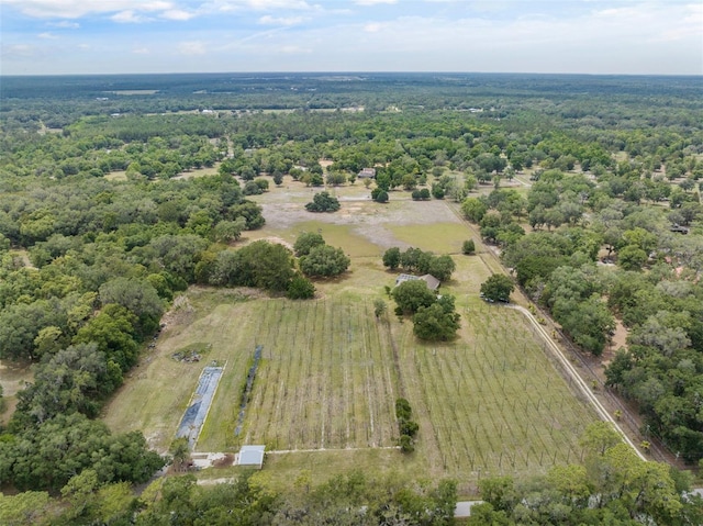 birds eye view of property featuring a view of trees and a rural view