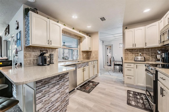 kitchen featuring white cabinets, appliances with stainless steel finishes, and sink