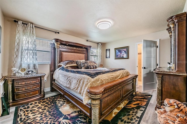 bedroom featuring light hardwood / wood-style floors and a textured ceiling