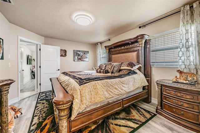 bedroom featuring light wood-type flooring and a textured ceiling