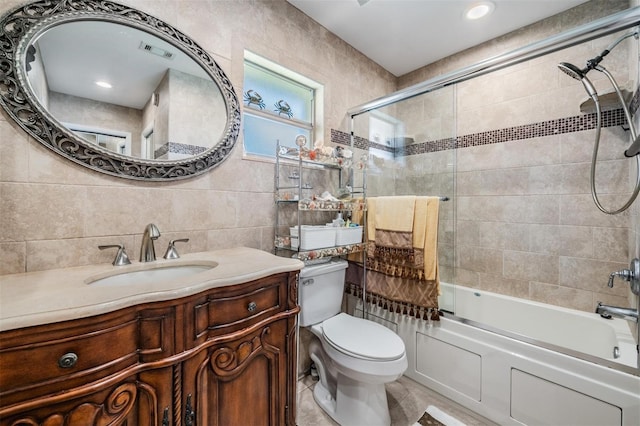 full bathroom with tile patterned flooring, enclosed tub / shower combo, tile walls, toilet, and vanity