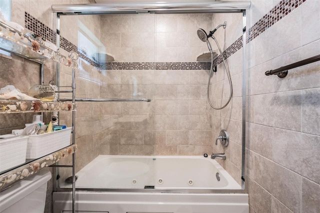 bathroom with toilet and combined bath / shower with glass door