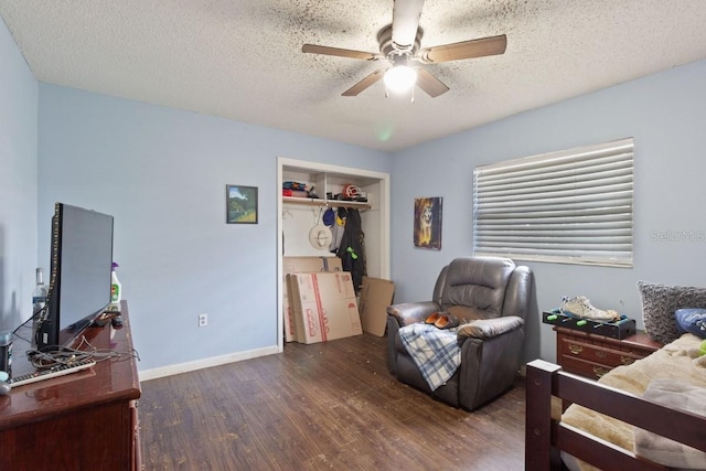 bedroom with ceiling fan, dark hardwood / wood-style floors, a closet, and a textured ceiling