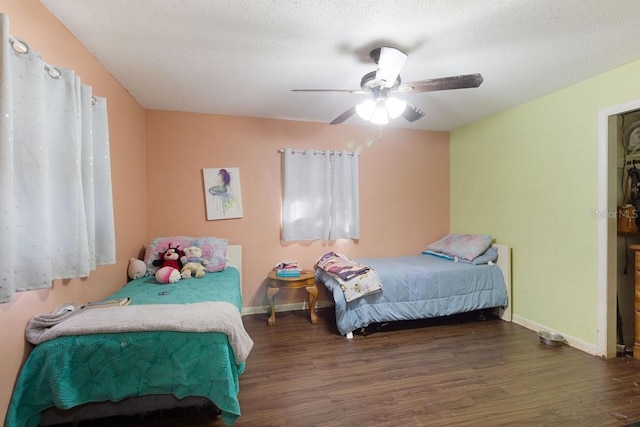 bedroom featuring dark wood-type flooring, ceiling fan, and a textured ceiling