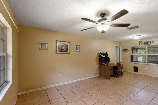 unfurnished office with ceiling fan, visible vents, a textured ceiling, and light tile patterned flooring