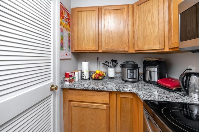 kitchen with light stone counters and electric stove