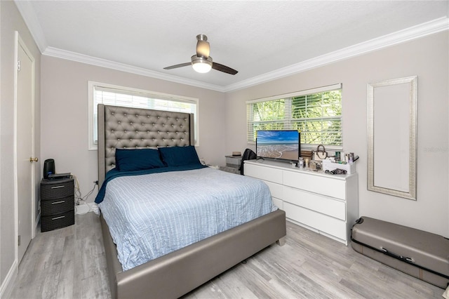 bedroom featuring crown molding, light wood-type flooring, and ceiling fan