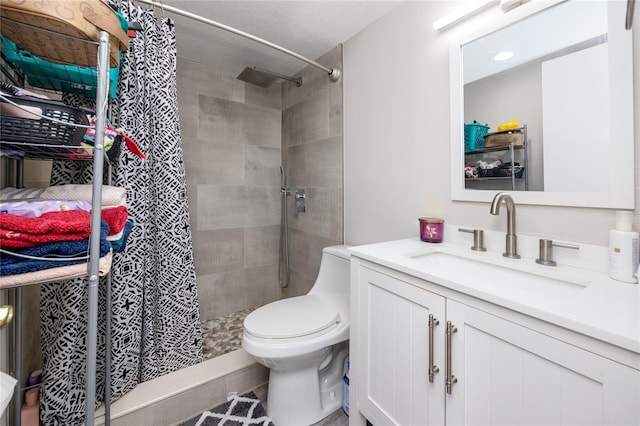 bathroom with vanity, toilet, and a tile shower