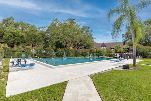 view of swimming pool featuring a patio and a yard