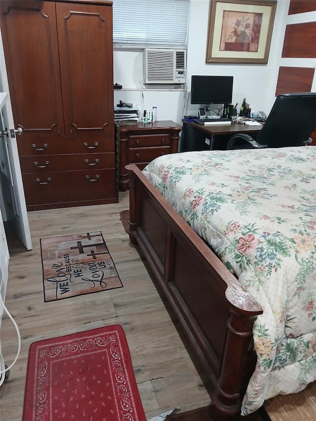 bedroom with cooling unit and light hardwood / wood-style floors