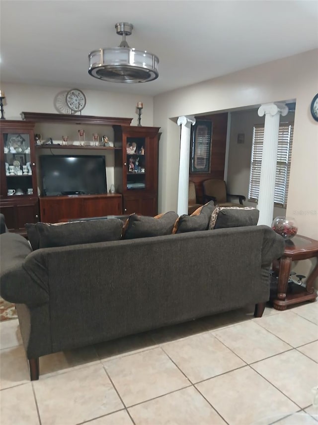 living room featuring decorative columns and light tile patterned flooring