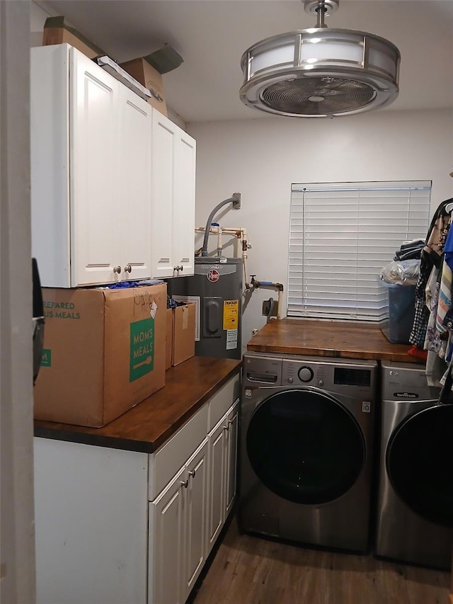 laundry area featuring washer and clothes dryer, dark hardwood / wood-style floors, cabinets, and electric water heater