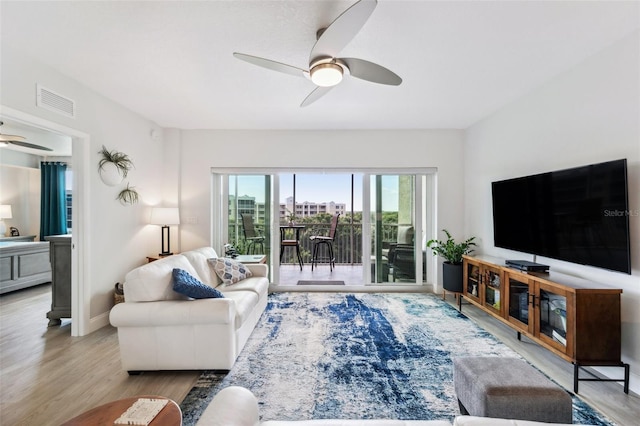 living room with ceiling fan and light hardwood / wood-style flooring