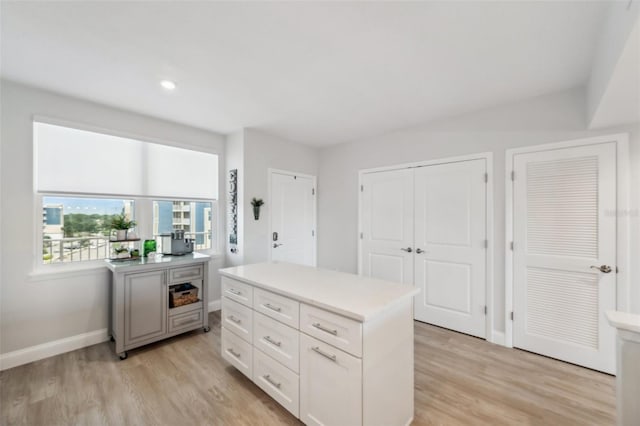 kitchen with white cabinetry, light hardwood / wood-style floors, and a center island