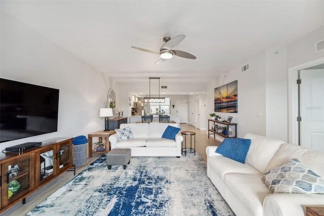 living room featuring ceiling fan and light hardwood / wood-style floors