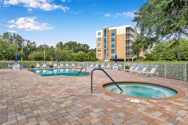 view of swimming pool with a patio area and a hot tub