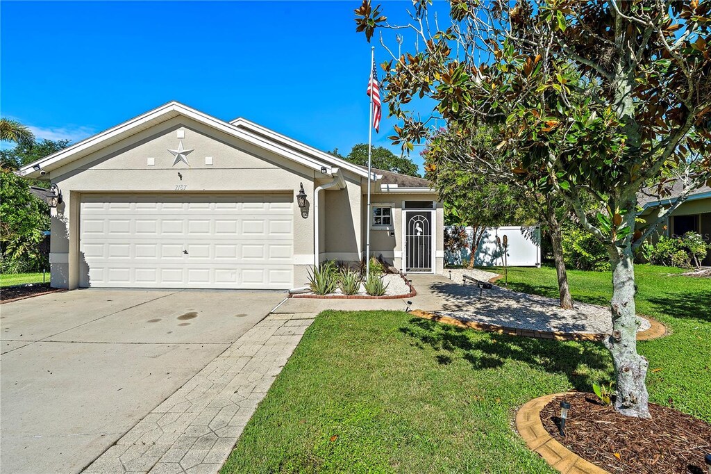 single story home with a garage and a front yard