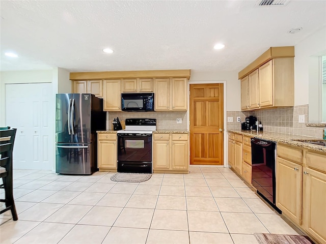 kitchen with light stone counters, light brown cabinets, black appliances, and light tile patterned flooring