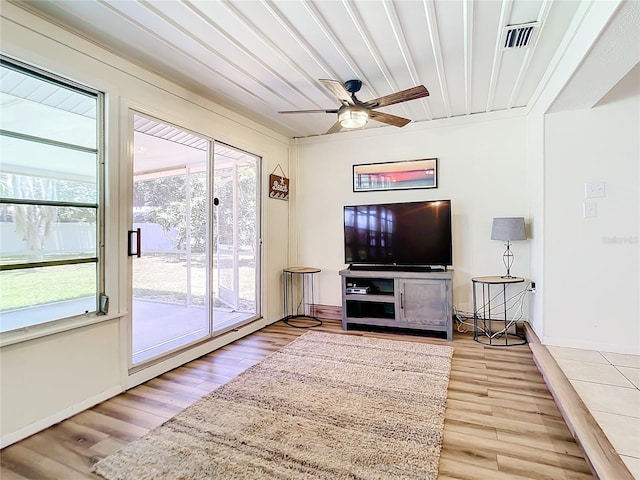 living room featuring ceiling fan, wood-type flooring, and a wealth of natural light