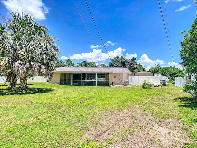 rear view of house with a sunroom and a yard