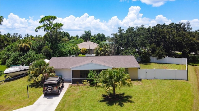 view of front of house featuring a sunroom and a front yard