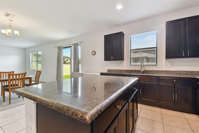 kitchen featuring sink, hanging light fixtures, a center island, and light tile patterned flooring