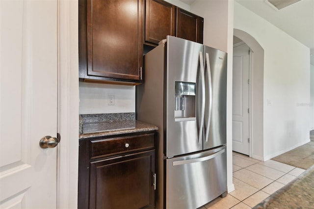 kitchen with light tile patterned floors, dark brown cabinets, and stainless steel refrigerator with ice dispenser